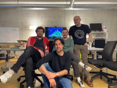 Vier Männer blicken in die Kamera.