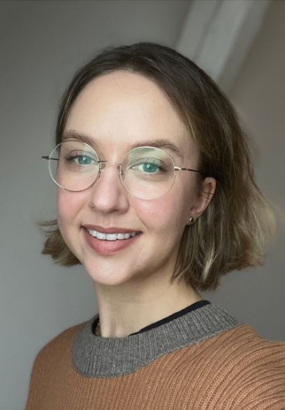 Johanna Stierlin schaut direkt in die Kamera. Sie trägt Brille und schulterlanges Haar.