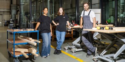 Das Projektteam von Design for Dignity steht in einer Werkstatt. Insgesamt sind drei Personen zu sehen.