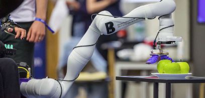 Roboterarm greift nach Apfel.