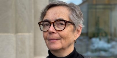 Porträtfoto einer Frau mit kurzen Haaren, Brille und schwarzem Rollkragenpullover, im Dreiviertelprofil aufgenommen.