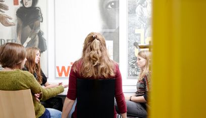 Eine Gruppe Studierender sitzt um einen Tisch.