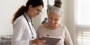 Photo of a medical professional showing a patient her journey map
