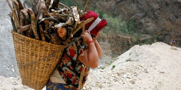 Frau in Nepal trägt Holzkorb